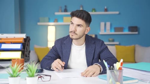 Young businessman reading and signing documents.