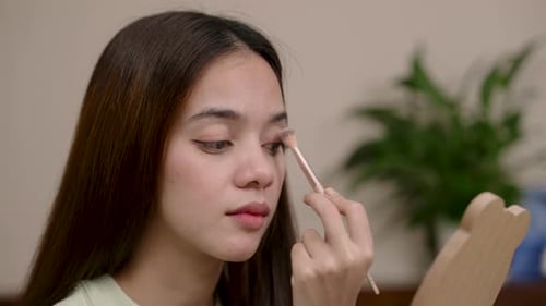 Woman Applies Eyeshadow at Home