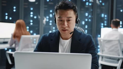 Close Up Asian IT Developer Administrator Wearing Headset Speaker Using Laptop Computer Server Room
