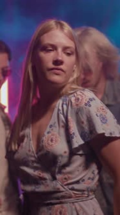 A Cheerful Young Woman is Joyfully Dancing at a Vibrant and Colorful Celebration Party