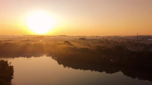 Fog rising in a forest during a beautiful idyllic sunrise