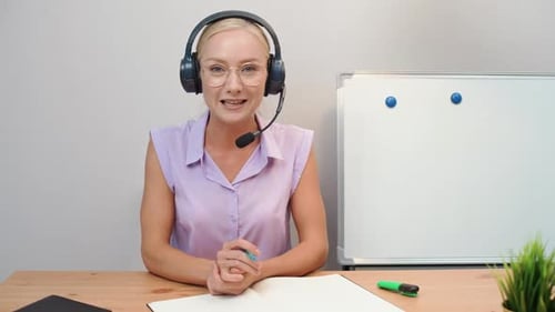 Woman in Headset Talking at Desk