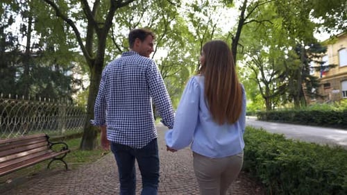Couple Holding Hands Walking in a Beautiful Park