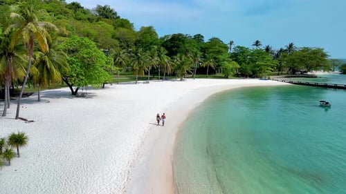 Couple Enjoying a Serene Walk on the Pristine Shores of Koh Kham Island in Thailand