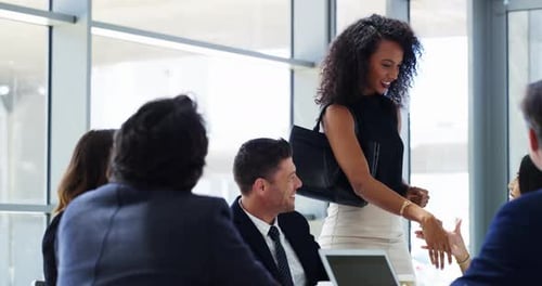 Young modern and professional businesswoman gives handshake in formal corporate office meeting