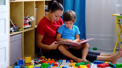 Feliz madre e hijo leyendo un libro, mamá sonriente, niñera
