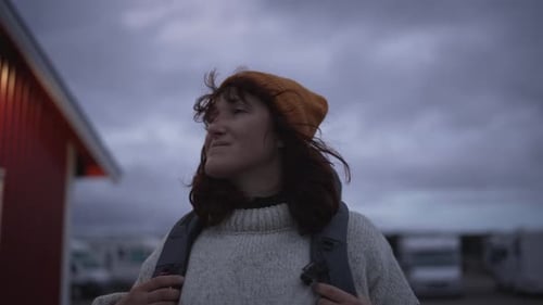 Amid the Shadowy Ambiance of Lofoten Norway a Striking Girl with a Bag Ventures Forth Traversing the