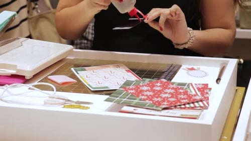 Gluing scrapbooking art for Christmas themed gift cards, paper crafts