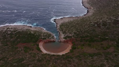 Aerial view of cliff and lagoon by the Mediterranean Sea, Greece.