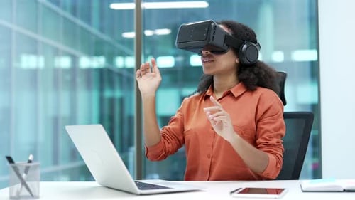 Successful young African American businesswoman works using VR glasses in virtual reality simulator