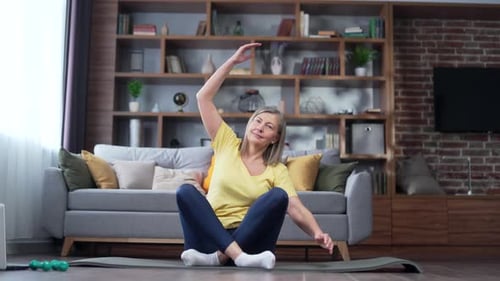 Woman Stretching on a Mat at Home