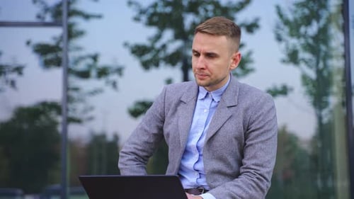 Young Adult Working on Laptop in City