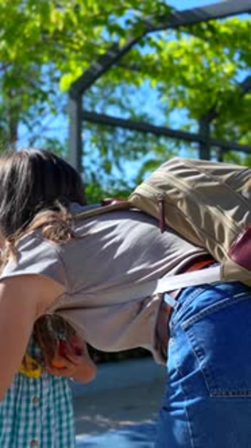 Madre le da un bocadillo de fruta saludable a su hija antes de la escuela