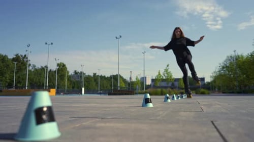 sporty girl practicing tricks on roller skates in park on city background enjoying roller skating