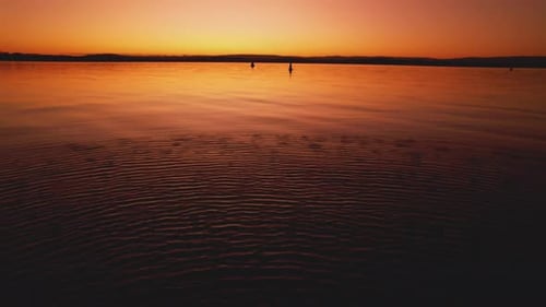 4k 30fps TILT and Dolly roll, shot of a calm water surface at sunset.