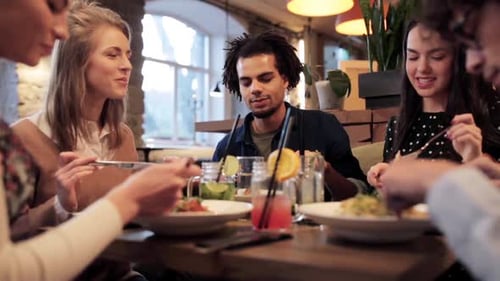 Friends Enjoying Food and Drinks in Restaurant Together