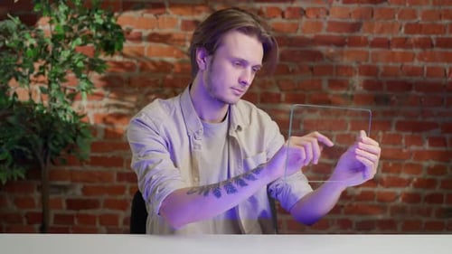 Man Holding Innovative Futuristic Tablet with Transparent Glass Screen Swiping and Watching Media