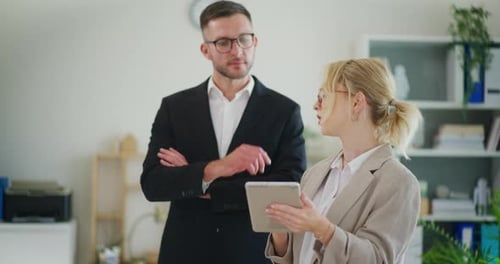 Business Colleagues Discussing Data on Tablet in Office