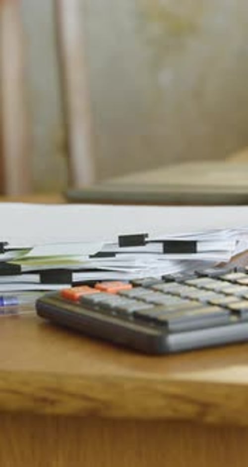 Vertical Video of a Human Putting a Stack of Sheets on a Desk at the Office