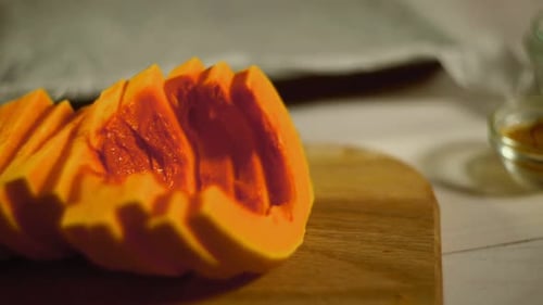 Raw Pumpkin Pieces. Close Up Pumpkin Slices on Wooden Board. Pumpkin Slices