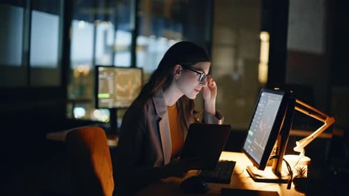 Analista financeiro trabalhando no computador na estação de trabalho noturna com ações em tempo real