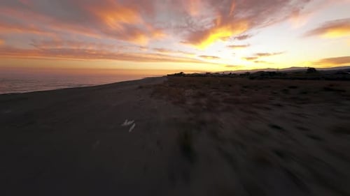 Flying Over a Sandy Coast Lighted By Sunrise
