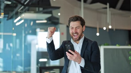 Joyful Business Triumph Mobile Phone Celebration in Office