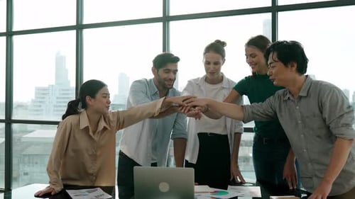 Diverse Team Stacking Hands in an Office Building