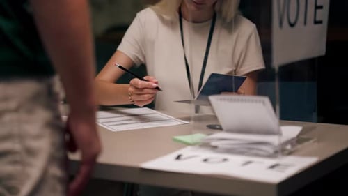 Close Up In the Selection Committee of the Election Company a Guy Registers to Vote a Young Girl