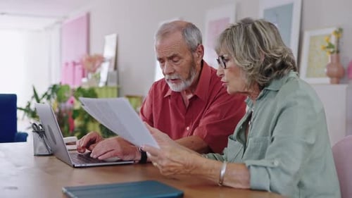 Senior Couple Discussing Documents at Home in Slow Motion