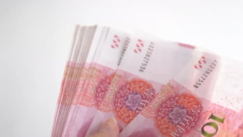 Close up of female hands counting numbers of hundred RMB Chinese paper money, abstract blur and whit