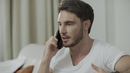 Young Man Talking on Cell Phone Indoors