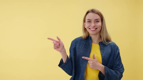 Smiling Woman Pointing to the Side on Yellow Background