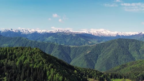 Green And Snowy Mountains Aerial View. Melting Snow On The Top Of The Mountains