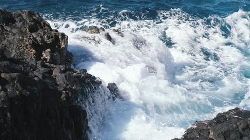 Eine große Welle des Atlantiks bricht an einer Felsenküste an einem sonnigen Tag während eines Sturms in der
