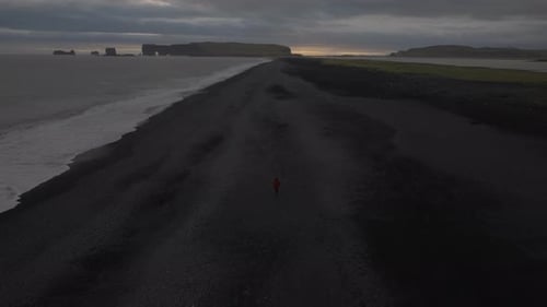Solitary Figure on a Vast Icelandic Beach at Dusk