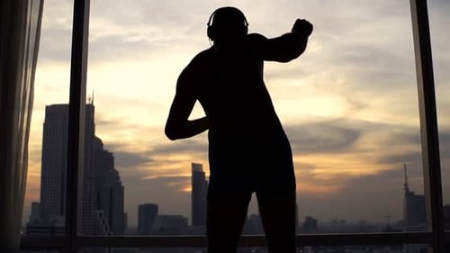 Man Listening to Music and Dancing near Window