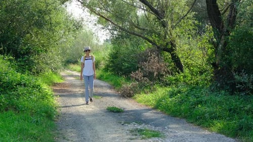 Woman Hiking Through a Lush Forest Enjoying the Natural Surroundings