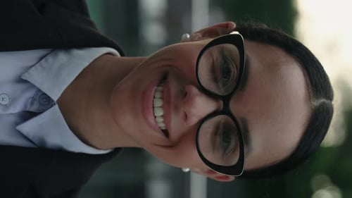 Smiling Woman Wearing Glasses in Corporate Setting