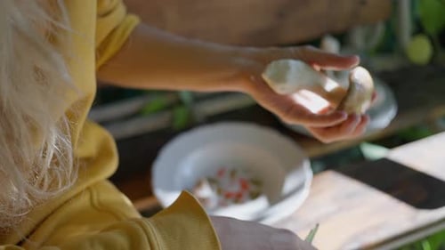 A Woman Cleaning Porcini Mushrooms in the Garden with a Knife