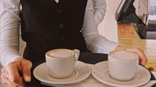 Mittleres Steadicam-Video von Kellner und Kaffee auf einem Tablett beim Gehen