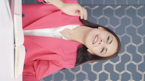 Smiling Woman in Pink Blazer During Video Call