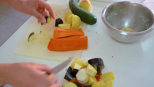Chopping Various Vegetables On Cutting Board In Kitchen - high angle, close up