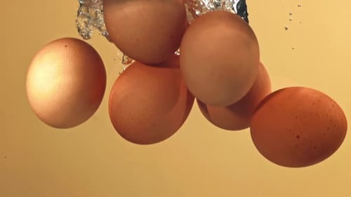 Eier fallen mit Blasen unter Wasser, gefilmt mit einer Hochgeschwindigkeitskamera mit 1000 Bildern pro Sekunde
