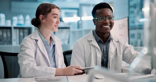 Scientists Collaborating on Computer in Modern Laboratory