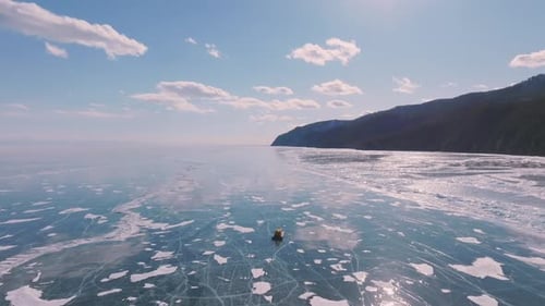 Hovercraft auf dem gefrorenen Baikalsee mit rissigem Eis und Blick auf die Winterküste