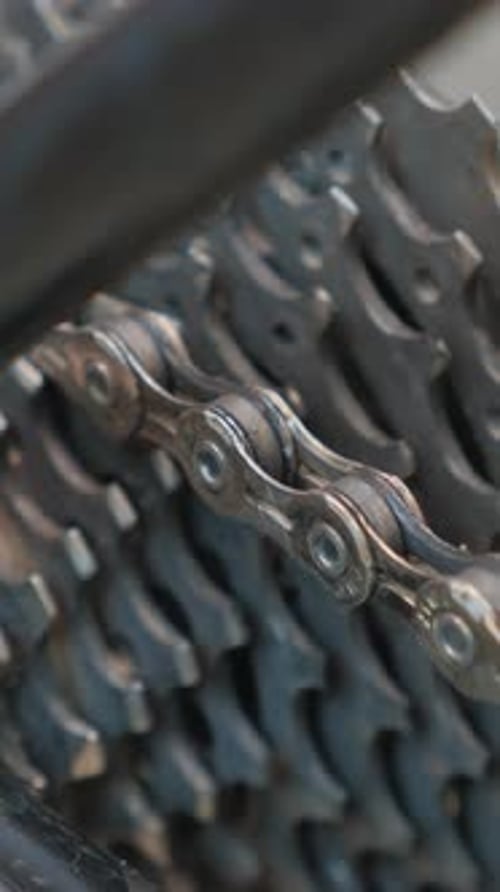 Close up of rotating rear bicycle wheel derailleur and chain. Vertical video