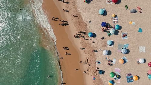 A Vibrant Beach Scene Featuring Beachgoers Relaxing Under Colorful Umbrellas By the Shore