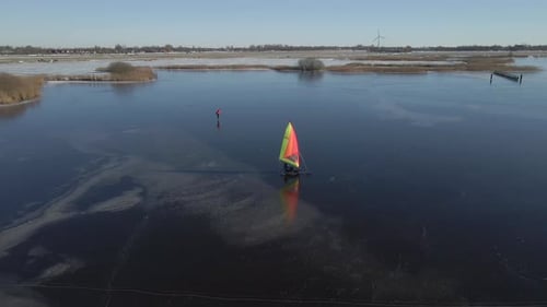 Aerial view of man ice sailing on frozen lake during winter
