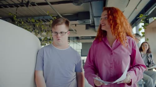 Woman Talking to Man with Developmental Disability in Office